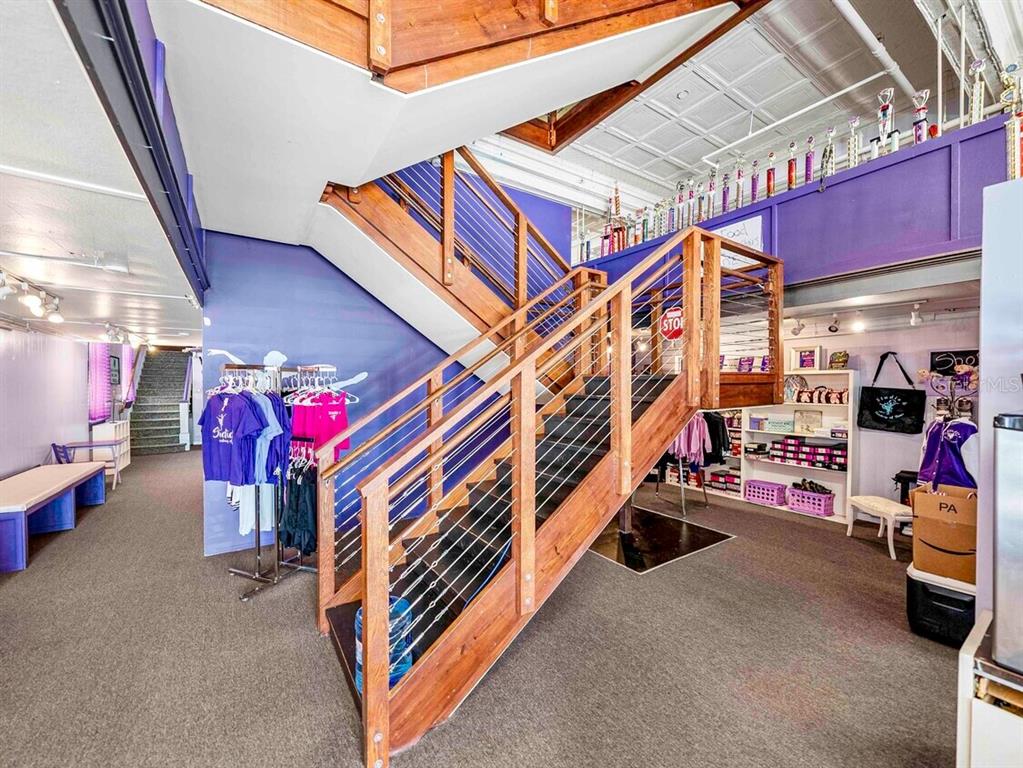 A dance studio interior features a central wooden staircase with cable railings and purple walls — 247 E STUART AVENUE, LAKE WALES, FL