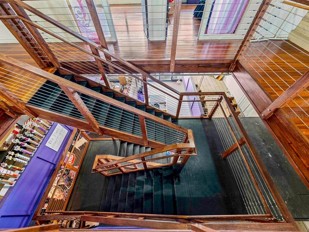 A high-angle view shows a wooden staircase with cable railings leading to a landing — 247 E STUART AVENUE, LAKE WALES, FL