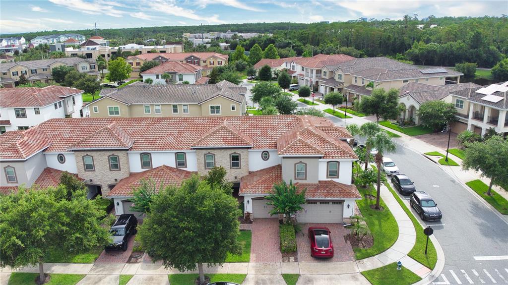 An aerial view of a multi-unit residential building with terracotta tile roofs and paved driveways — 13880 ARCLID STREET, ORLANDO, FL