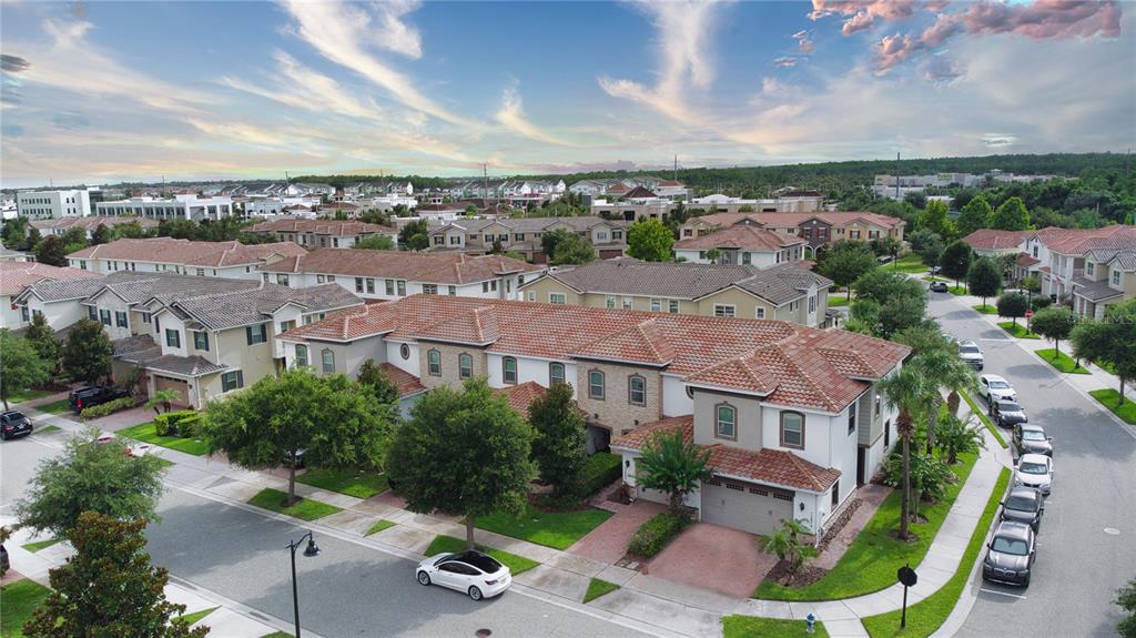 An aerial view shows a multi-unit residential building with tile roofs and attached garages — 13880 ARCLID STREET, ORLANDO, FL