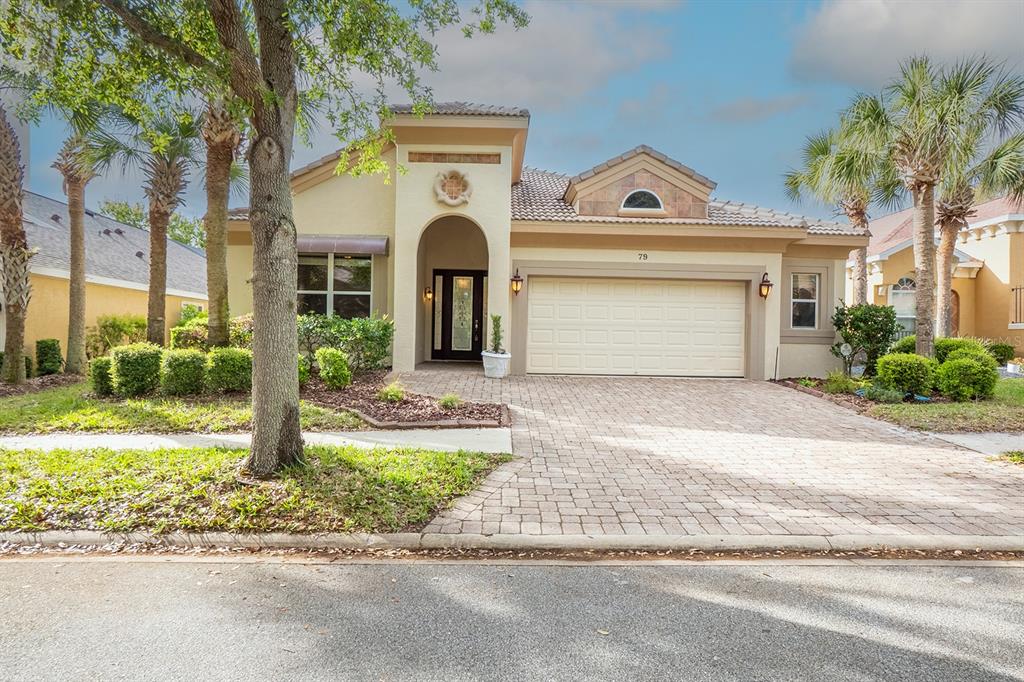 A single-story house with a beige stucco exterior, a tiled roof, and a paved driveway — 79 SOUTHLAKE DRIVE, PALM COAST, FL