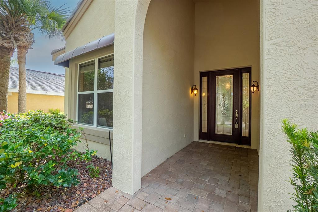 An entryway with tile flooring, a high ceiling, a pendant light, and a glass-paneled door — 79 SOUTHLAKE DRIVE, PALM COAST, FL