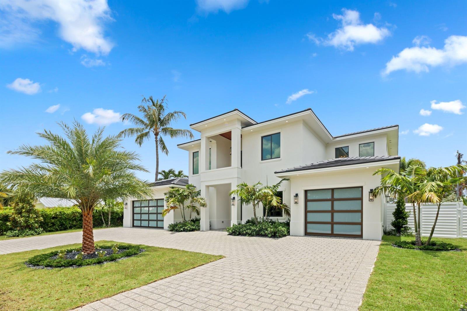 A two-story modern house with a paved driveway, two garages, and palm trees — 1160 Emerald Drive, Riviera Beach FL 33404, RIVIERA BEACH, FL
