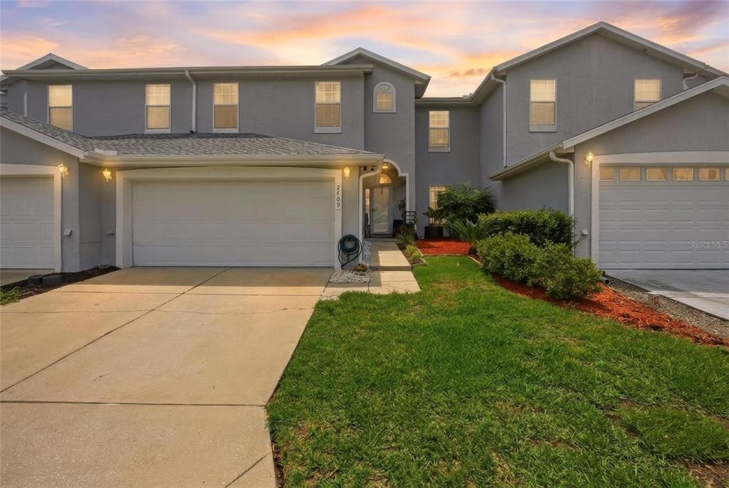 A two-story suburban house features a two-car garage, a concrete driveway, and a small lawn — 2409 SW 20TH TERRACE, OCALA, FL
