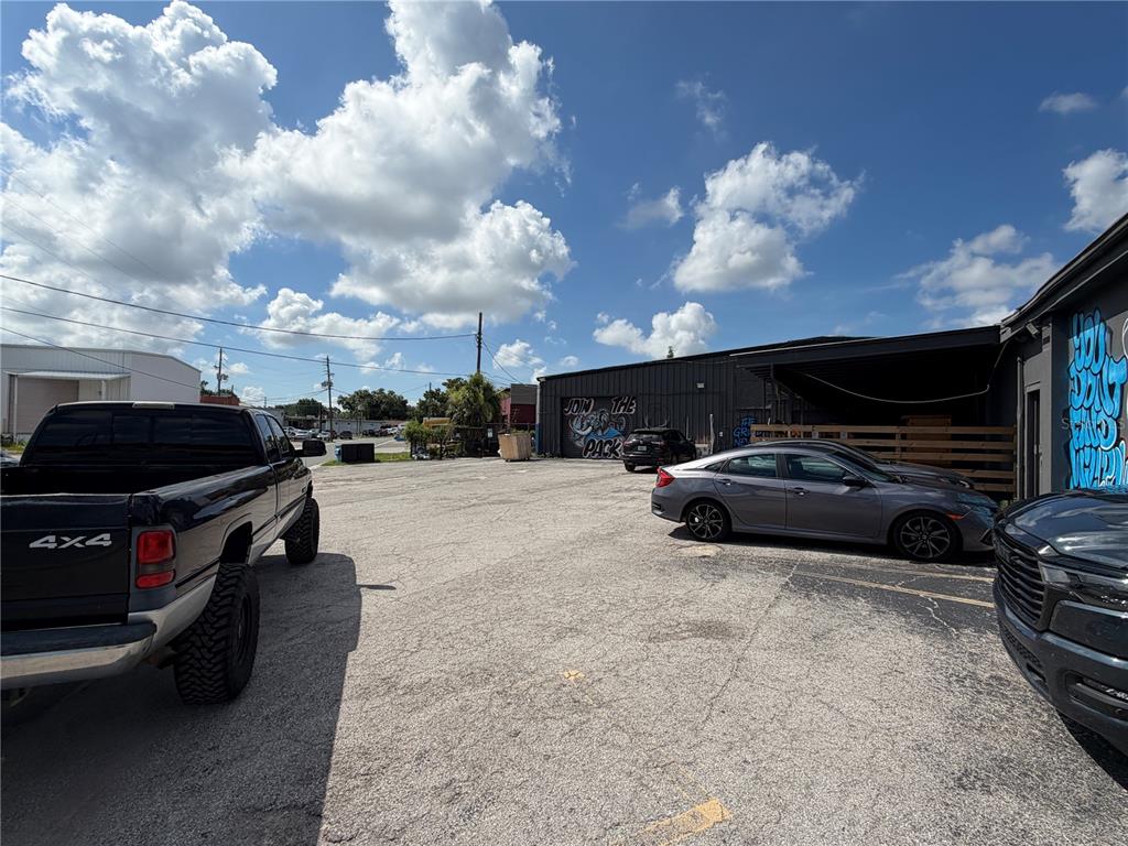 An outdoor parking lot with several parked vehicles next to a commercial building — 5983 49TH STREET N, ST PETERSBURG, FL