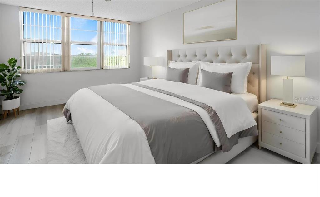 A bright bedroom features a tufted headboard, white bedding, and a large window with blinds — 4020 W PALM AIRE UNIT 402, POMPANO BEACH, FL