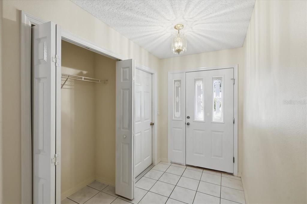 An entryway features a white front door, a coat closet, and light-colored floor tiles — 4 PONY LANE UNIT A & B, PALM COAST, FL