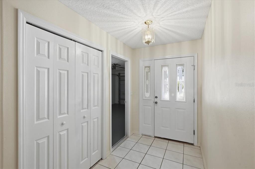 An entryway features white tile flooring, a closet with bifold doors, and a front door — 4 PONY LANE UNIT A & B, PALM COAST, FL