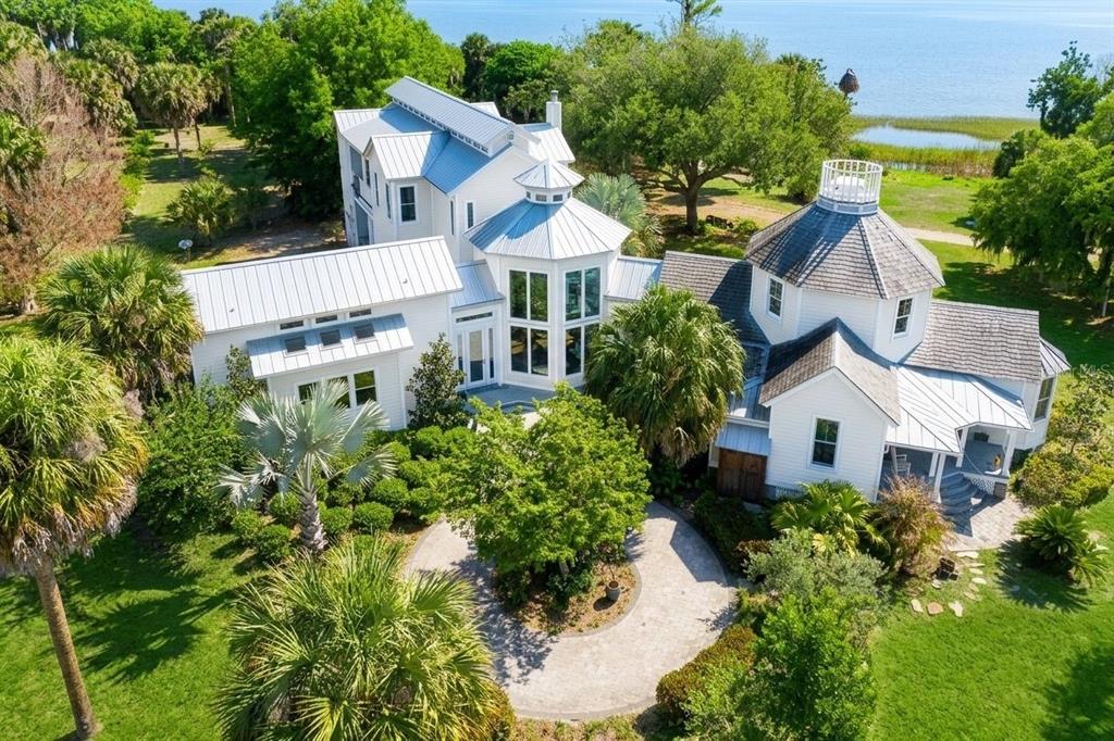 An aerial view of a white multi-story house with metal roofs and a circular driveway — 7950 BANNON FISH CAMP ROAD, HAINES CITY, FL