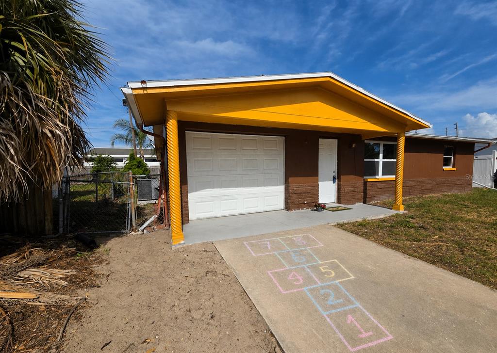 A view from a covered porch looking out toward a residential street and neighboring houses — 4645 IRENE LOOP, NEW PORT RICHEY, FL