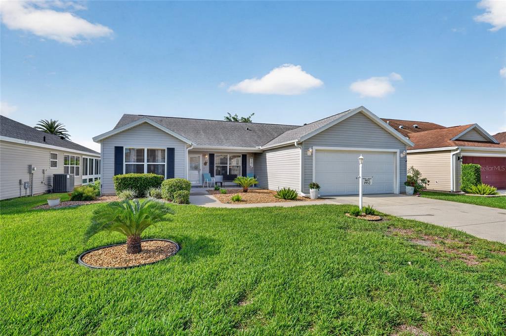 A single-story house with light gray siding, a two-car garage, and a manicured front lawn — 1952 ARDMORE WAY, THE VILLAGES, FL