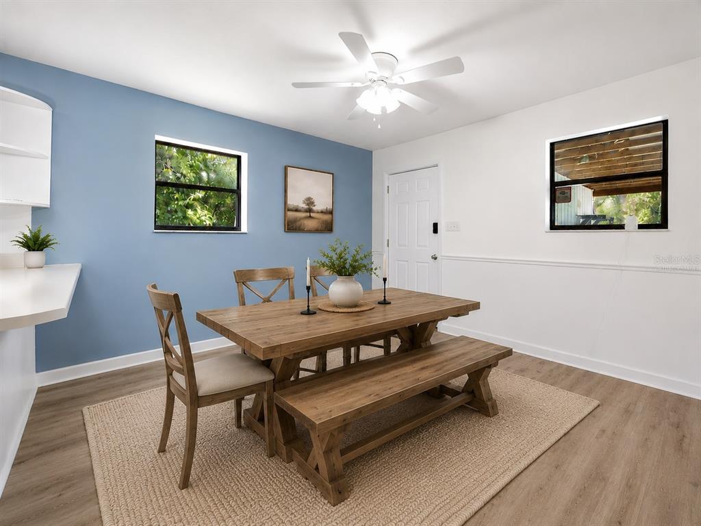 A dining room features a wooden table with a bench, chairs, and a blue accent wall — 9419 NW 235TH TERRACE, ALACHUA, FL