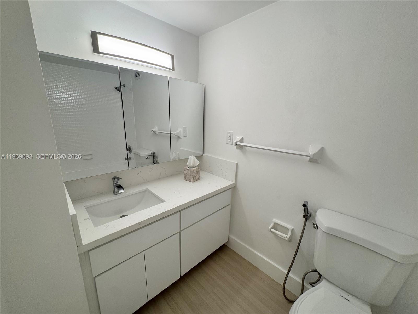 A modern bathroom features a white vanity with a stone countertop and a toilet — 2899 Collins Ave # 740, Miami Beach FL 33140, MIAMI BEACH, FL