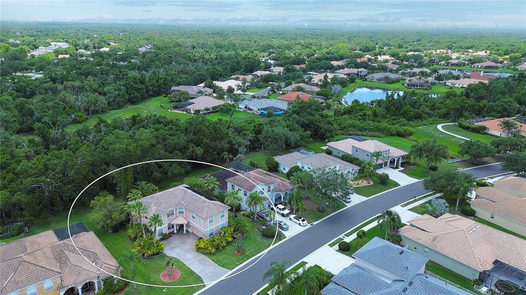 An aerial view shows a two-story suburban house with a tiled roof and landscaped yard — 267 PETREL TRAIL, BRADENTON, FL
