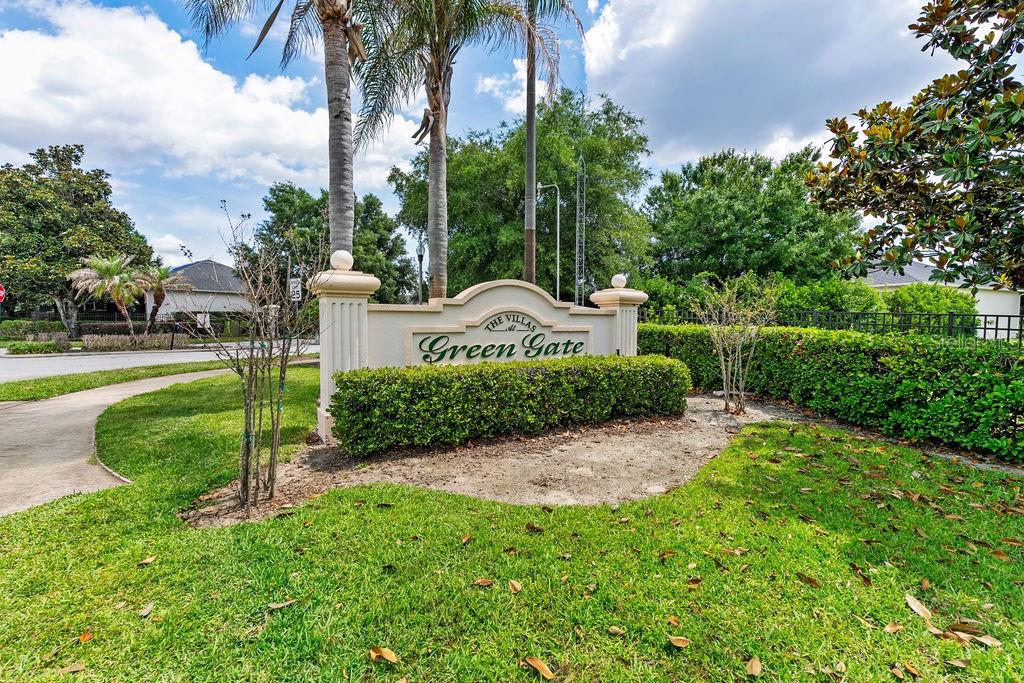 A stone monument sign for The Villas at Green Gate stands in a grassy yard — 1016 GREEN GATE BOULEVARD, GROVELAND, FL