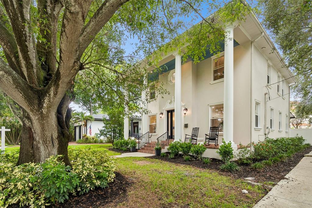 A two-story house with white columns and a front porch sits behind a large tree — 2722 N MYRTLE AVENUE, TAMPA, FL