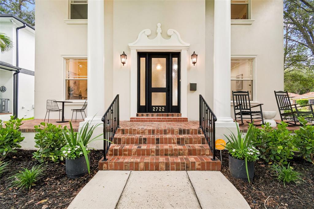 A brick staircase leads to a black front door with a decorative white pediment — 2722 N MYRTLE AVENUE, TAMPA, FL