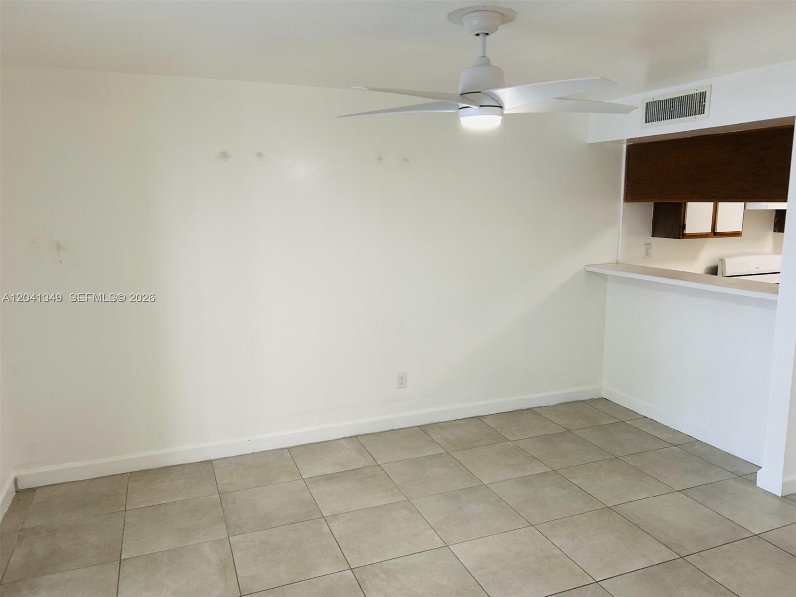 An empty room features white walls, tile flooring, and a ceiling fan — 15325 SW 106th Ter # 614, Miami FL 33196, MIAMI, FL