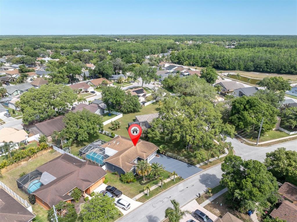 An aerial view shows a residential house with a pool enclosure and a red pin — 4851 DEER LODGE ROAD, NEW PORT RICHEY, FL