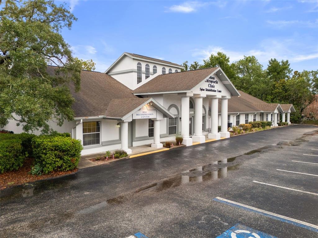 The exterior of a white commercial building with columns and a large parking lot — 1377 DELTONA BOULEVARD, SPRING HILL, FL