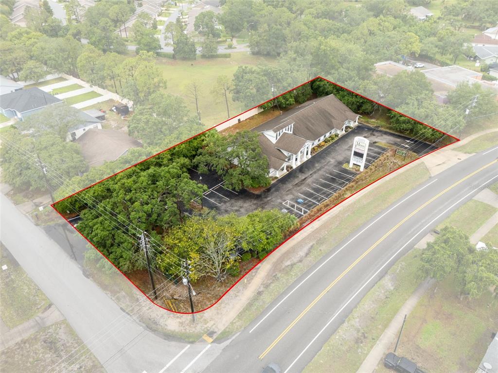 An aerial view shows a commercial building with a parking lot outlined in red — 1377 DELTONA BOULEVARD, SPRING HILL, FL
