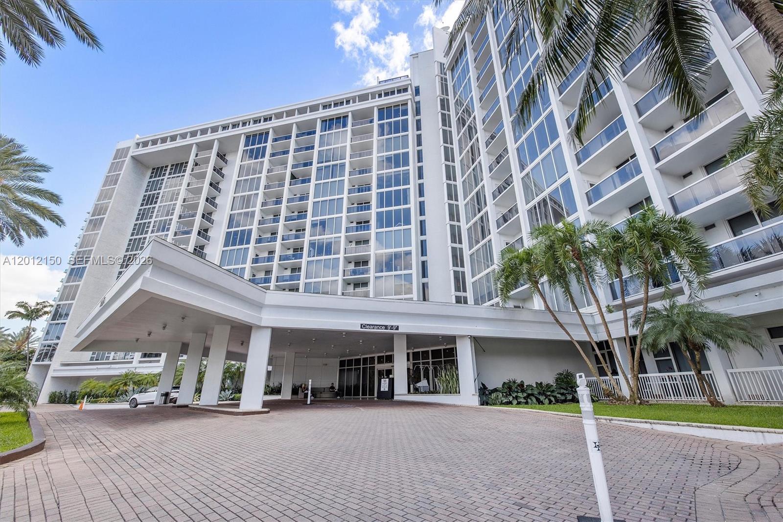 A multi-story white residential building features a large covered entrance with a paved driveway — 10275 Collins Ave # 1530, Bal Harbour FL 33154, BAL HARBOUR, FL