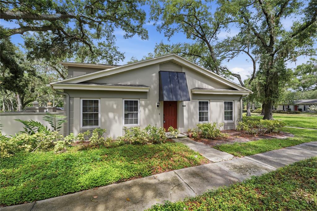 A galley kitchen features light wood cabinets, gray countertops, a tile backsplash, and a skylight — 6214 DEWDROP WAY, TEMPLE TERRACE, FL
