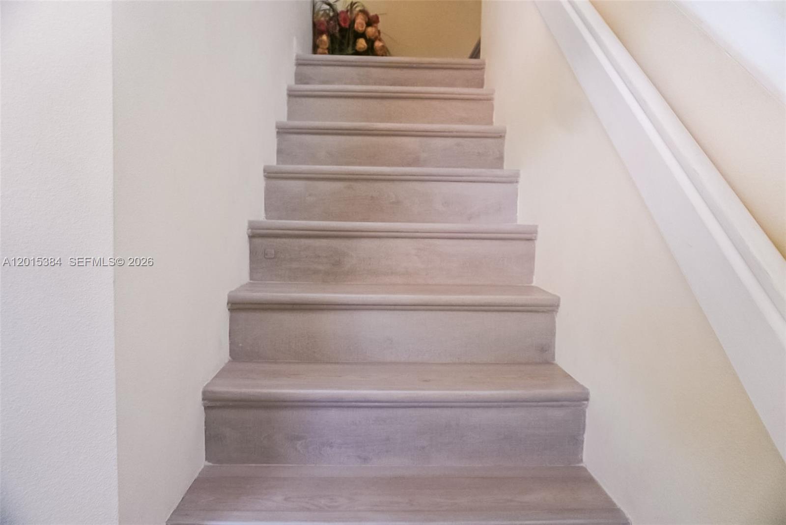 A straight wooden staircase with light-toned treads leads upward between two plain walls — 6864 Sugarloaf Key St, Lake Worth FL 33467, LAKE WORTH, FL