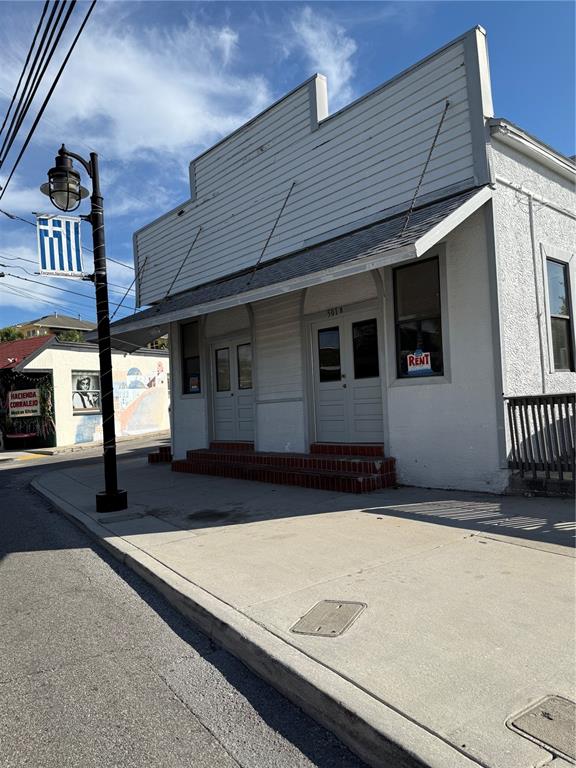 A white, single-story commercial building with a metal awning and two front entrance doors — 501 ATHENS STREET UNIT A & B, TARPON SPRINGS, FL