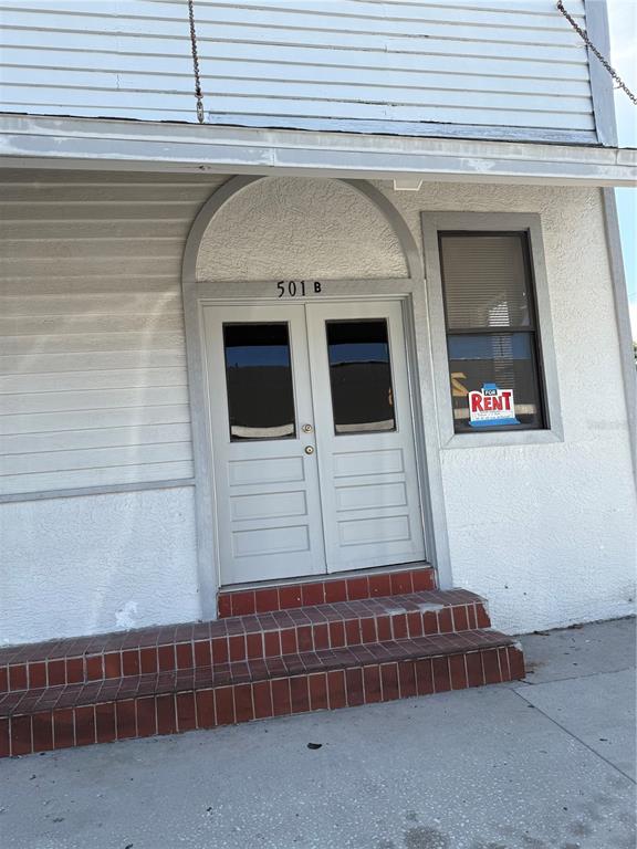 A white building exterior features a double door entrance with a brick step entry — 501 ATHENS STREET UNIT A & B, TARPON SPRINGS, FL
