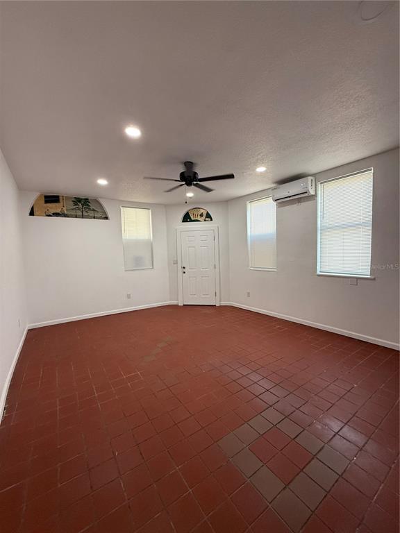 A room with red tile flooring, a ceiling fan, recessed lighting, and a white door — 501 ATHENS STREET UNIT A & B, TARPON SPRINGS, FL