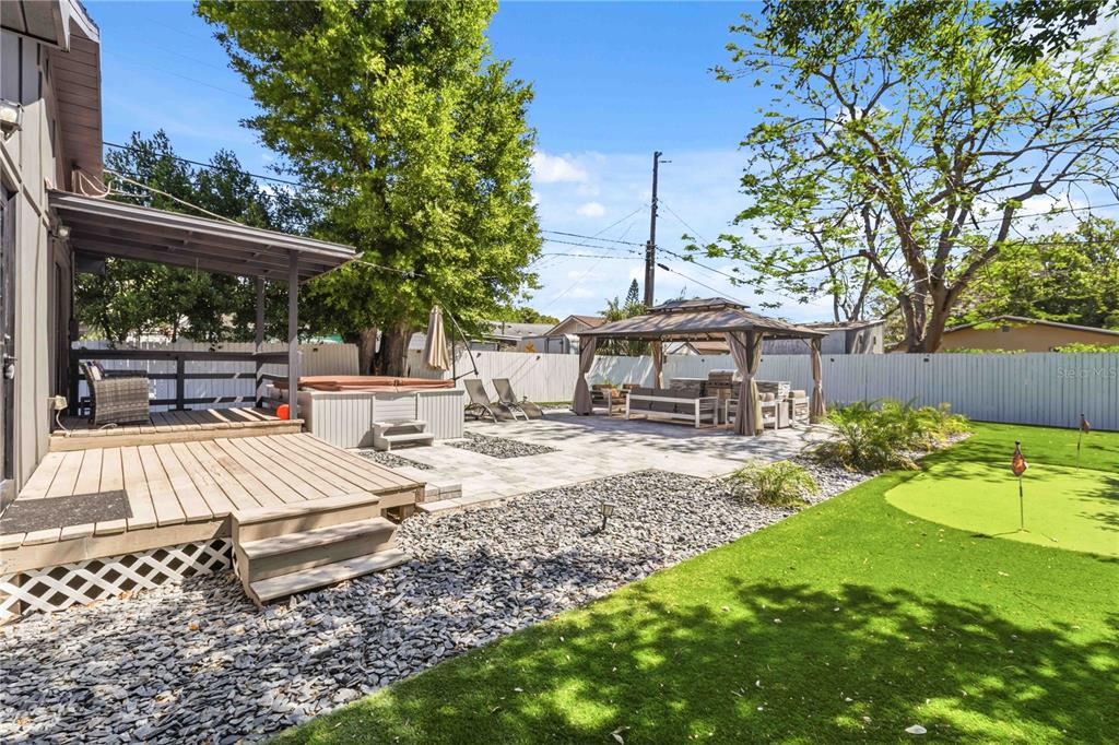 A backyard features a wooden deck, a hot tub, a gazebo, and a putting green — 2925 24TH STREET N, ST PETERSBURG, FL