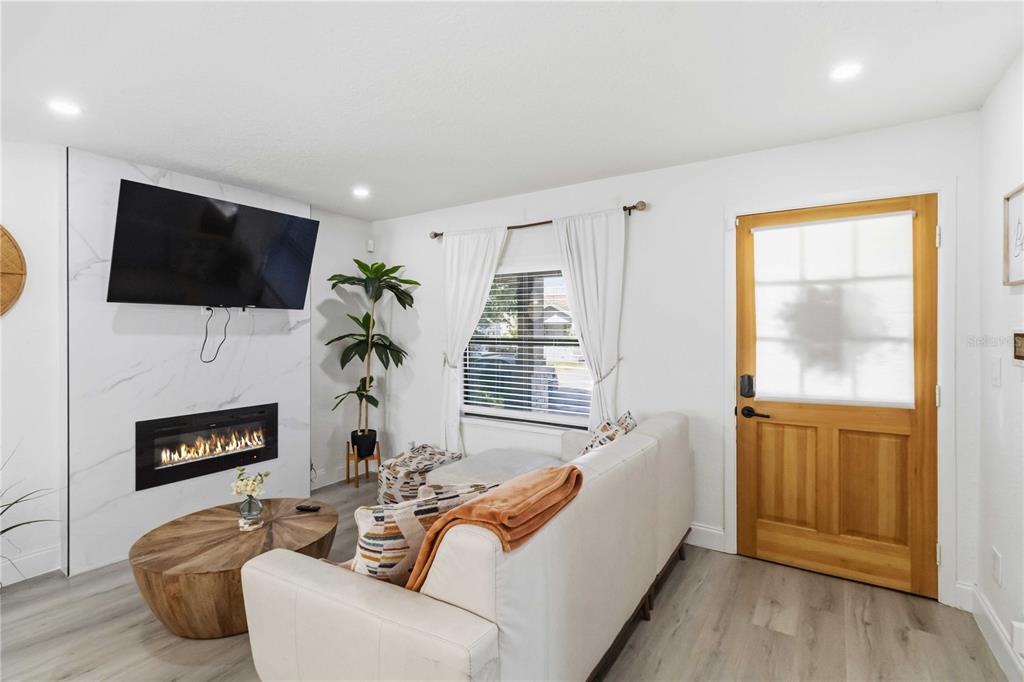 A living room features a sectional sofa, a round coffee table, and a fireplace — 2925 24TH STREET N, ST PETERSBURG, FL