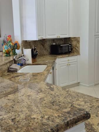 A kitchen features white cabinets, granite countertops, a sink, and a black toaster oven — 6671 E Liseron # 6671, Boynton Beach FL 33437, BOYNTON BEACH, FL