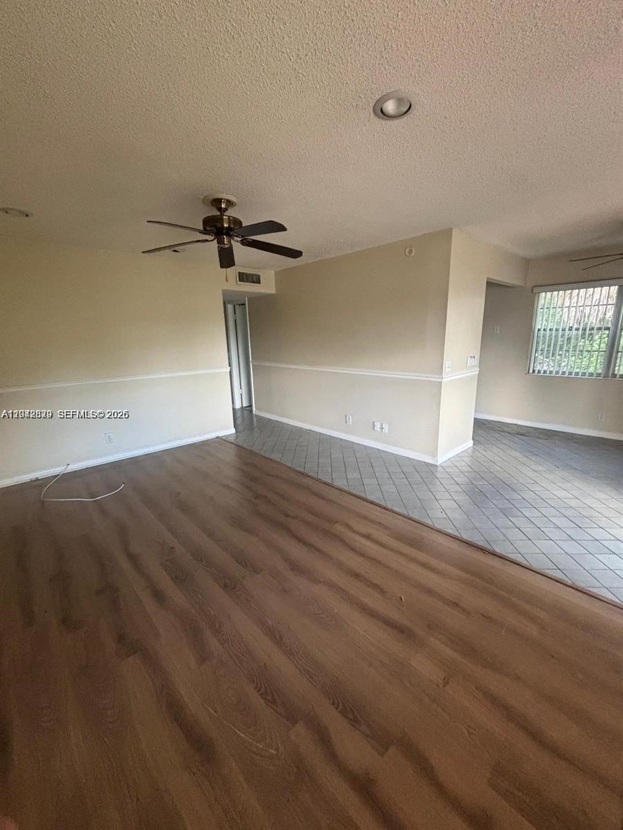 An open-concept living area features wood-look flooring, a ceiling fan, and tiled dining space — 280 Northampton, West Palm Beach FL 33417, WEST PALM BEACH, FL