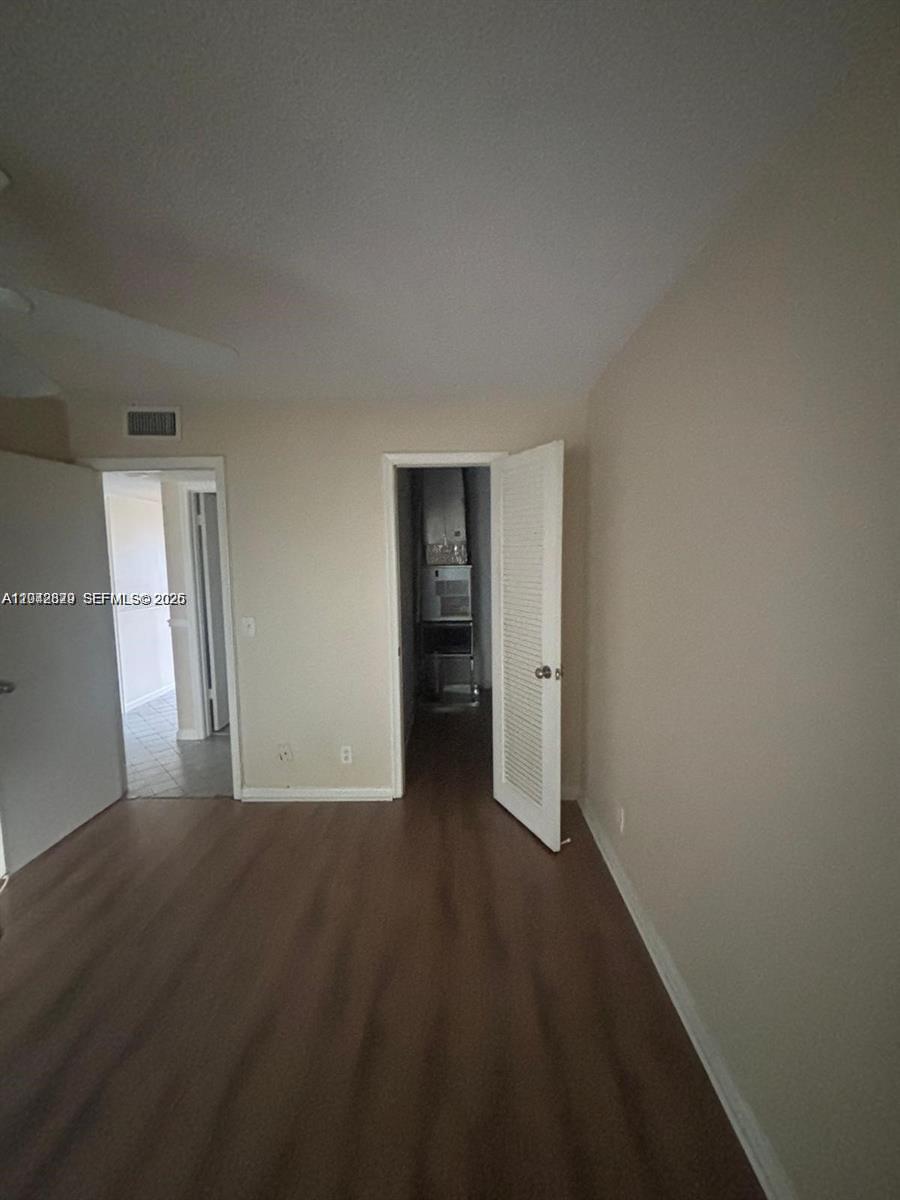 An interior room features wood-look flooring, beige walls, and two open doorways — 280 Northampton, West Palm Beach FL 33417, WEST PALM BEACH, FL