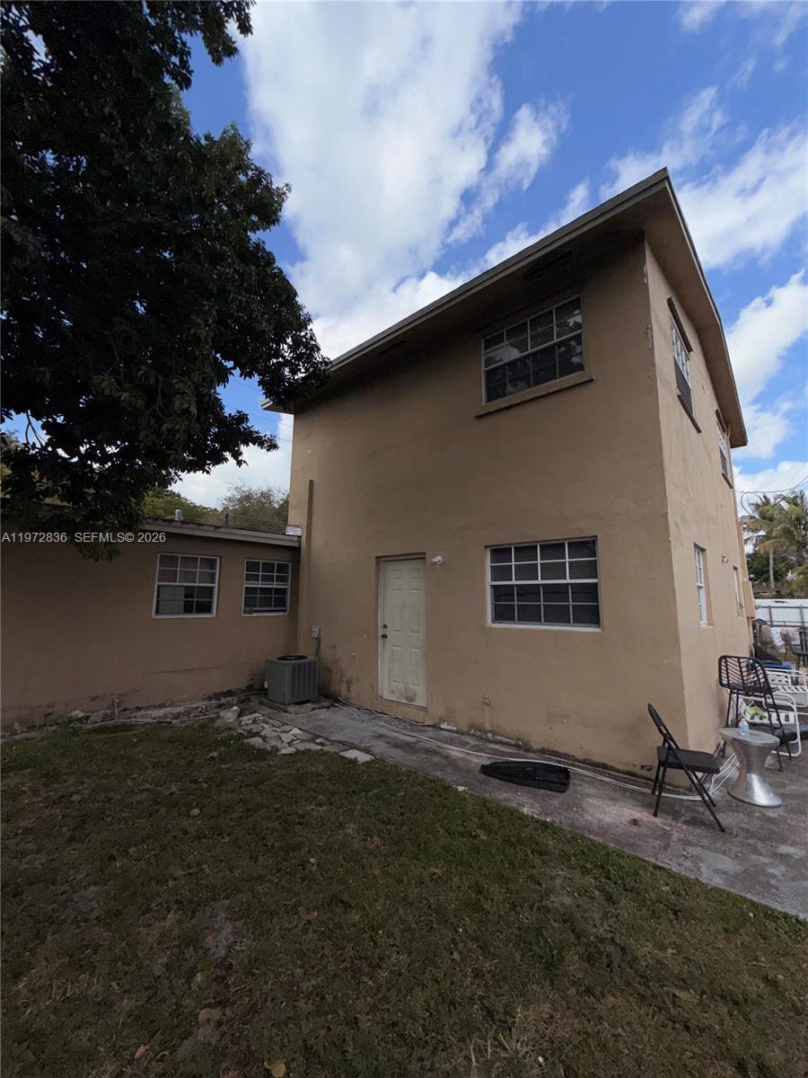 The exterior of a two-story beige stucco building features multiple windows and a single door — 7191 Park St, Hollywood FL 33024, HOLLYWOOD, FL