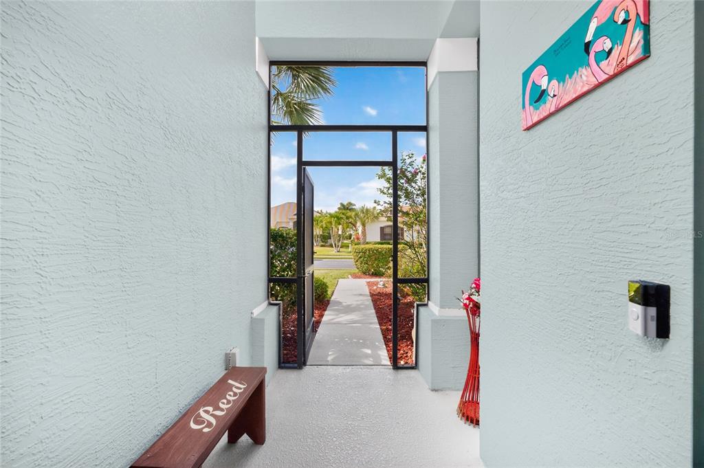 A view from an entryway looking out through an open door toward a suburban street — 24416 LAKEVIEW PLACE, PORT CHARLOTTE, FL