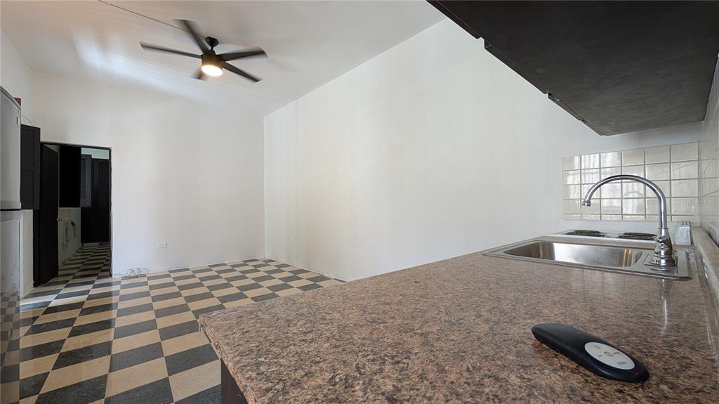 A kitchen with a checkered floor, granite-look countertop, and a ceiling fan — 153 SOL ST. UNIT 8, SAN JUAN, PR