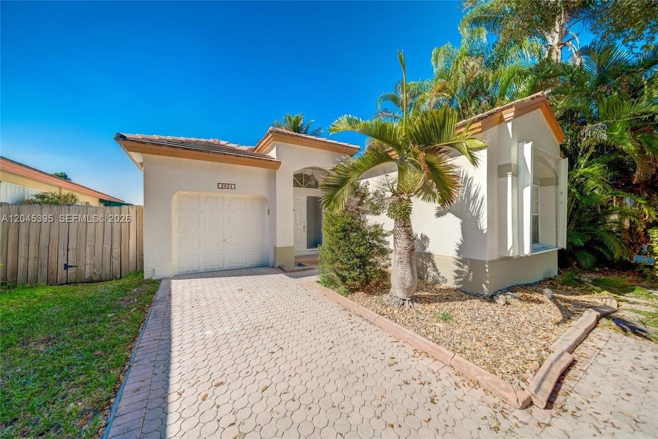 A single-story house with a white stucco exterior, a one-car garage, and a paved driveway — 2924 NW 99th Pl, Doral FL 33172, DORAL, FL