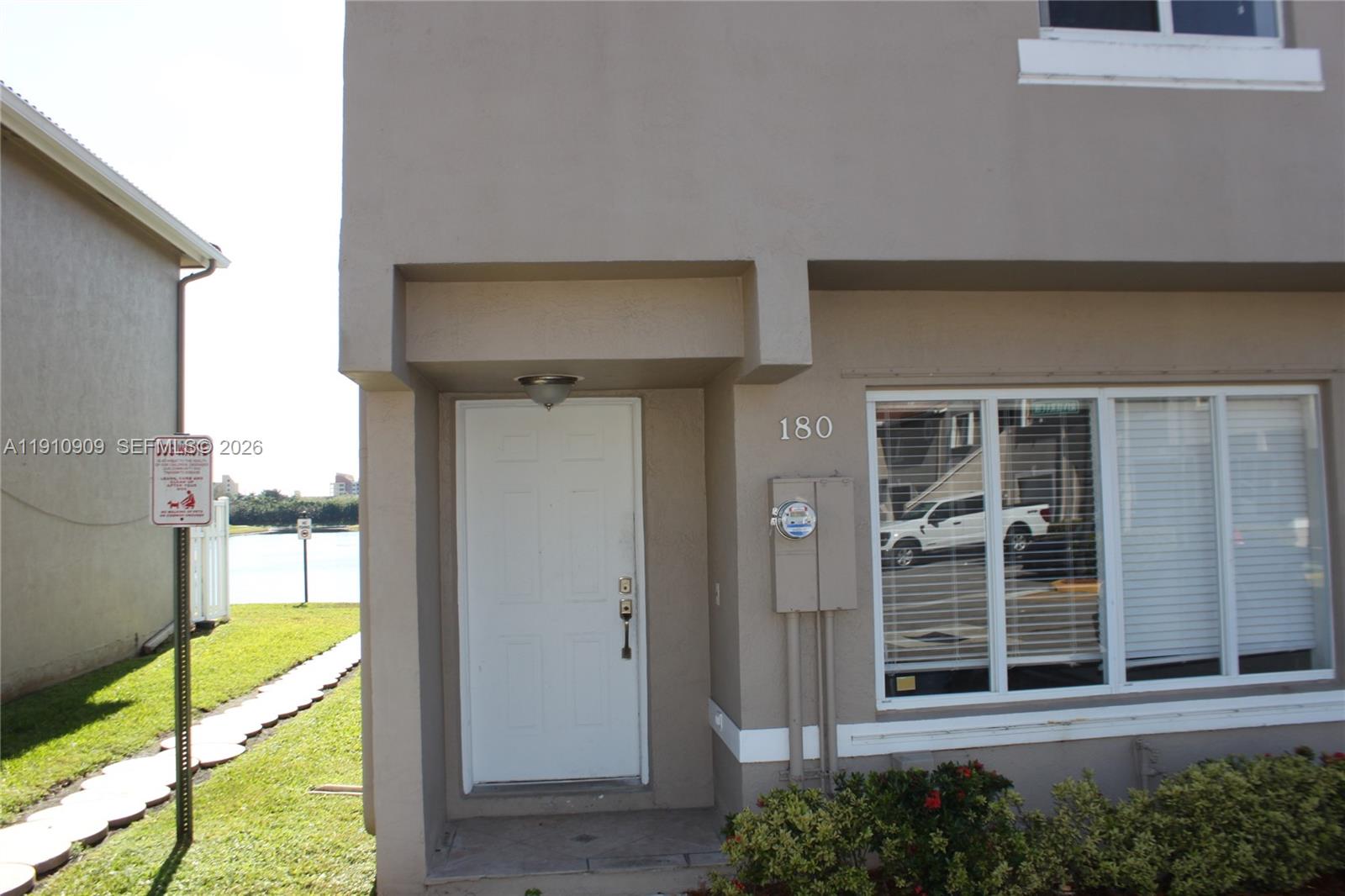 The exterior view shows a tan townhouse entrance with a white door and house number — 180 Riviera Cir # 5, Weston FL 33326, WESTON, FL