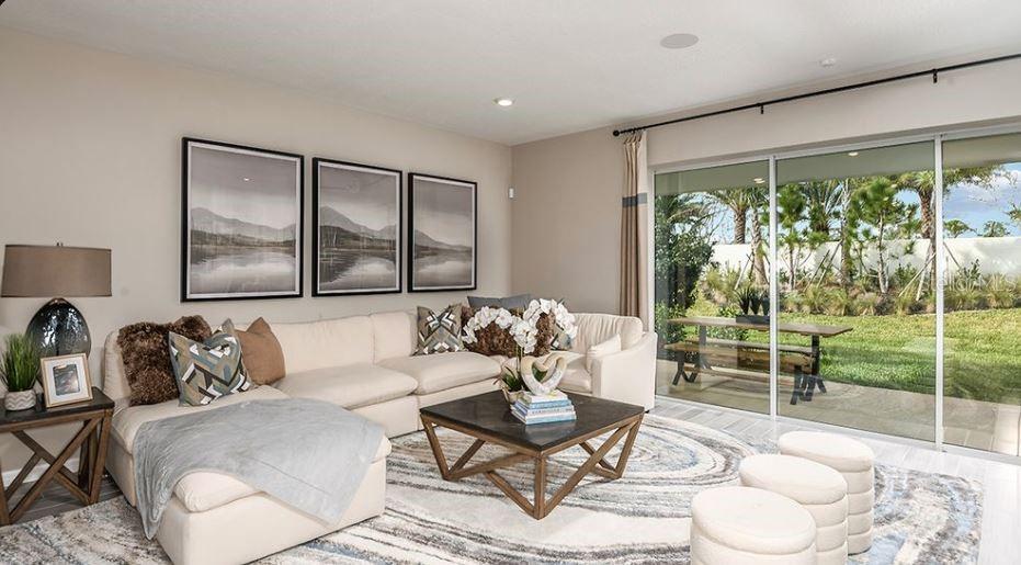 A living room features a cream sectional, a coffee table, and sliding glass doors — 844 STEEL DRIVE, APOLLO BEACH, FL