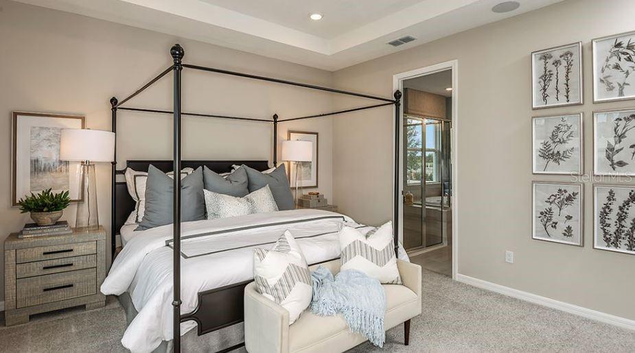 A bedroom features a black metal canopy bed, a bench, and framed botanical wall art — 844 STEEL DRIVE, APOLLO BEACH, FL