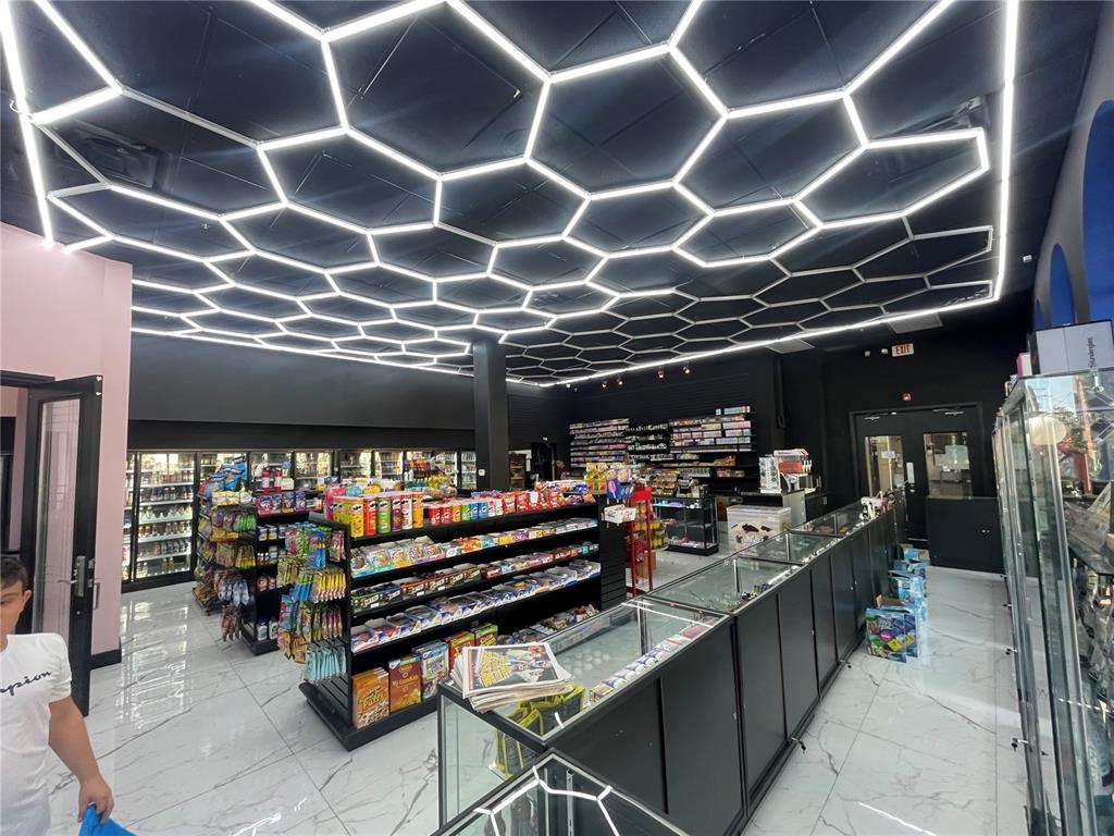 A retail store interior features a black ceiling with hexagonal LED lighting and marble flooring — 1880 E PALM AVENUE, TAMPA, FL