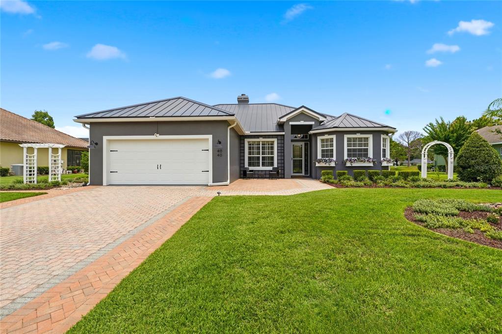 A single-story house with a gray exterior, metal roof, and a paved driveway — 4040 PALMA CEIA CIRCLE, WINTER HAVEN, FL
