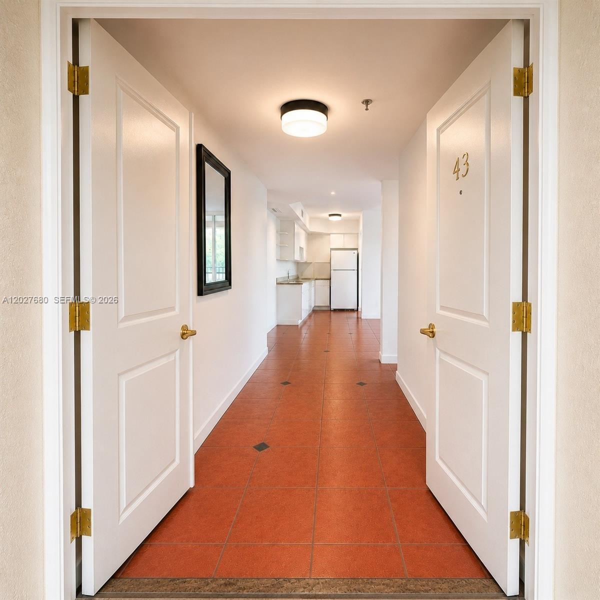 An open double-door entryway leads into a hallway with terracotta tile flooring and a kitchen — 1834 Brickell Ave # 43, Miami FL 33129, MIAMI, FL