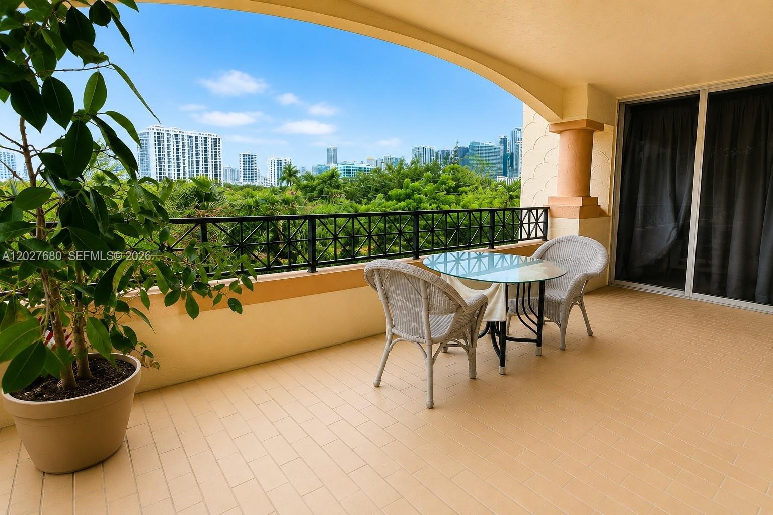 A balcony features a glass-topped table with two chairs, a potted plant, and city views — 1834 Brickell Ave # 43, Miami FL 33129, MIAMI, FL