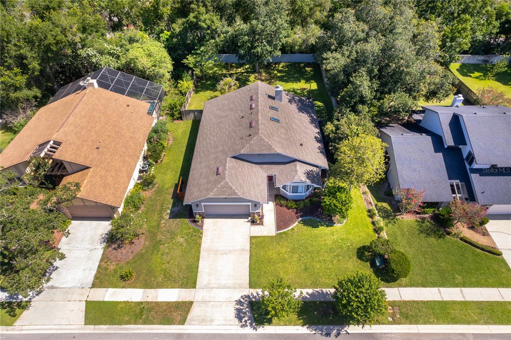 An aerial view shows a suburban house with a gray roof and a concrete driveway — 4651 TIFFANY WOODS CIRCLE, OVIEDO, FL