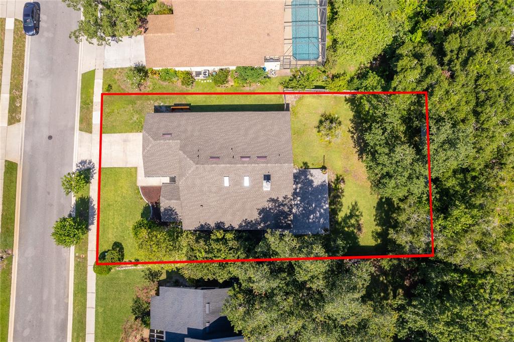 An aerial view shows a house with a shingled roof surrounded by a grassy yard — 4651 TIFFANY WOODS CIRCLE, OVIEDO, FL