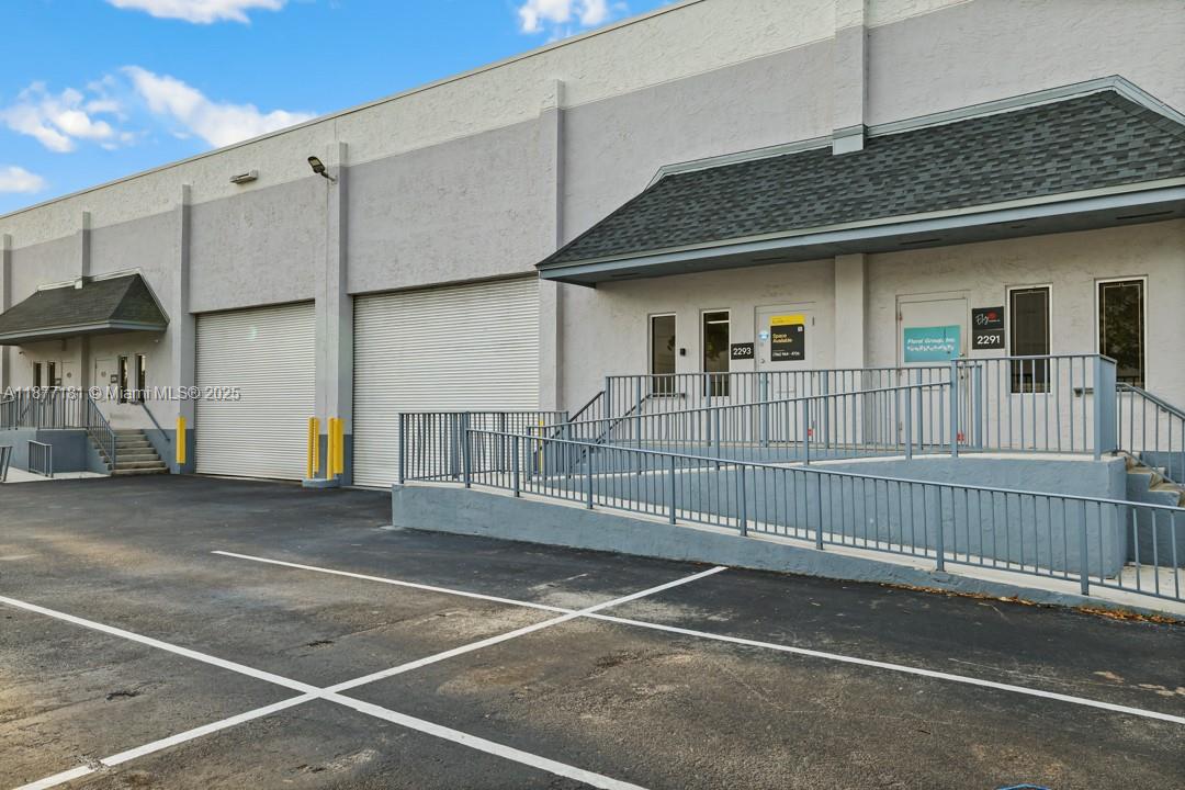The exterior of a commercial warehouse building features two roll-up doors and two entrance ramps — 2273 NW 82nd Ave # 2293, Doral FL 33122, DORAL, FL